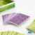 Baralho de cartas com verso roxo e detalhes florais, parte do jogo Village Green