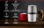 Molinillo eléctrico de café y semillas CG200 Gadnic de acero inoxidable junto a taza roja y saco de granos de café