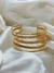 Bracelete dourado de tiras na internet