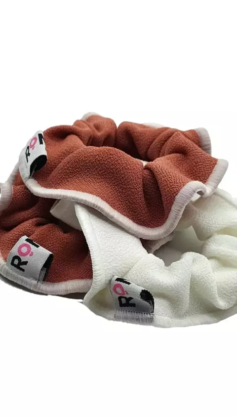 Set de colitas para el cabello en colores rosa y blanco con etiquetas de la marca.