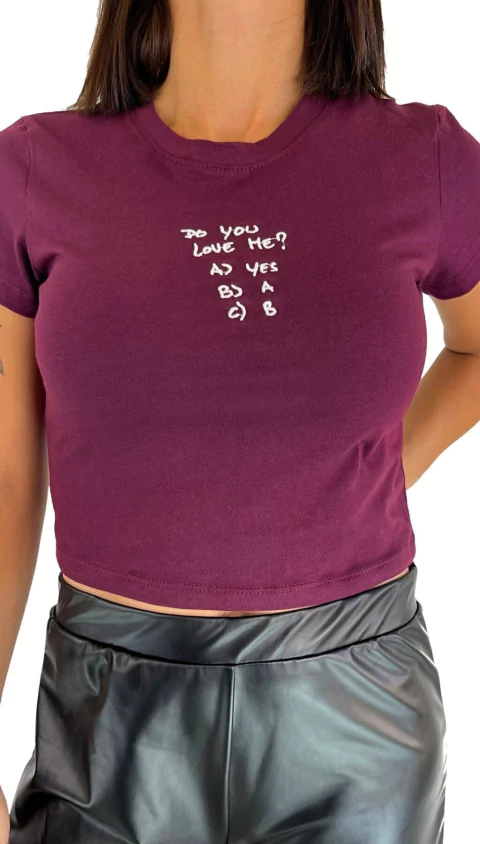 Remera corta color uva con inscripción "Do you love me?" en el pecho, modelo femenino, ideal para looks urbanos.