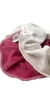 Set de tres accesorios de tela en colores blanco y rosa con etiquetas visibles.
