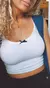 Top blanco sin mangas con detalle de lazo negro en el centro, parte de la colección OUTLET! TOP VICKY PAZ.
