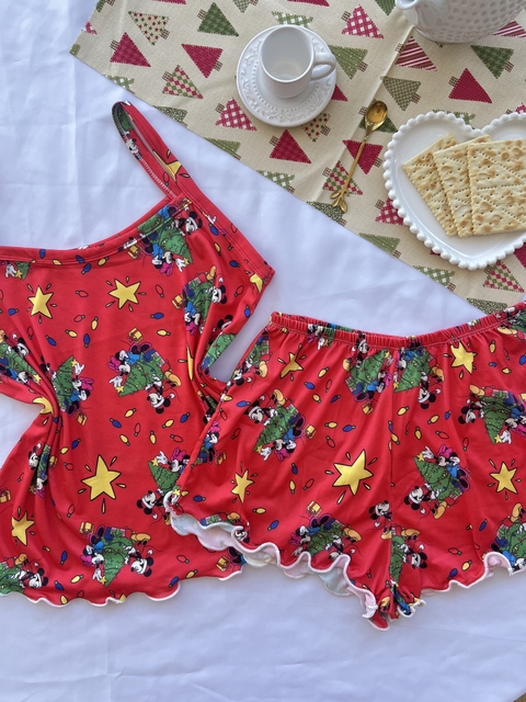 Conjunto de pijama infantil com estampa do Mickey e Minnie, composto por blusa regata vermelha e shorts, decorado com estrelas e árvores de Natal.
