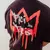 Camiseta cristã oversized preta com estampa vermelha de coroa e texto "Rei dos Reis" em estilo grafite na parte de trás