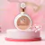 Frasco do perfume feminino Fakhar Rose EDP Parfum com fundo de flores rosas.