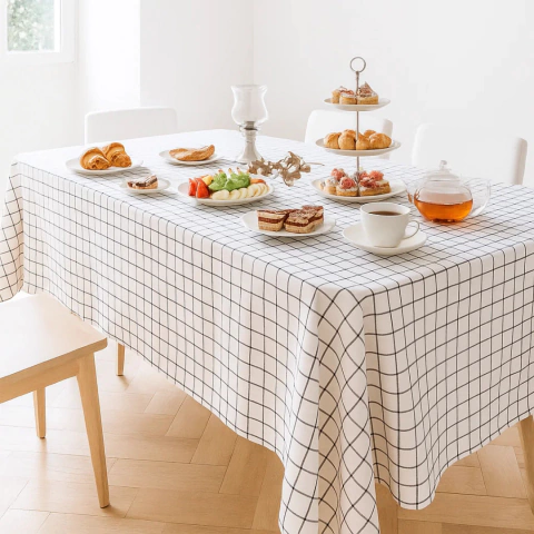 Mantel de tusor con diseño cuadriculado blanco y negro cubriendo una mesa con desayuno servido
