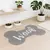Alfombra en forma de hueso con la palabra "Woof" en el centro