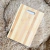Tabla de picar de bambú rectangular con diseño de vetas claras y oscuras, apoyada sobre una superficie de alfombra beige peluda
