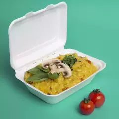 Estuche 600 con risotto amarillo, decorado con champiñones y hojas de albahaca, acompañado de tomates cherry.