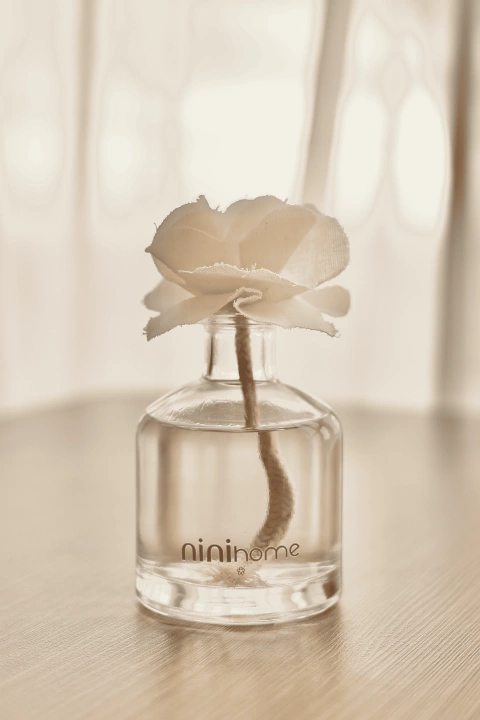 Difusor de aromas minimalista com flor de algodão artesanal, fragrância acolhedora e design sofisticado da Nini Home.