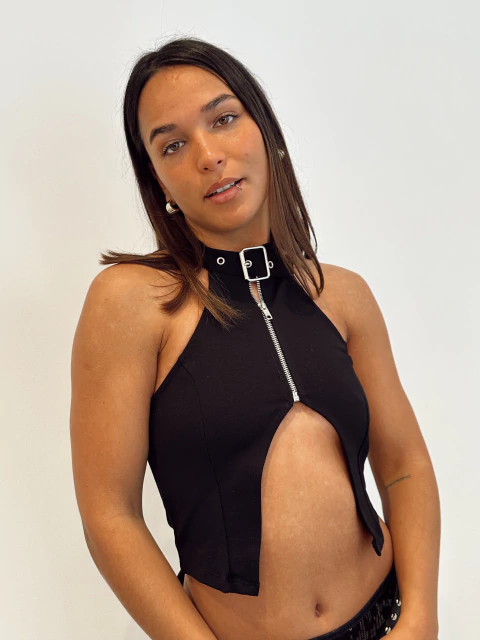 Modelo mujer con top negro sin mangas con cremallera y detalle de hebilla en el cuello