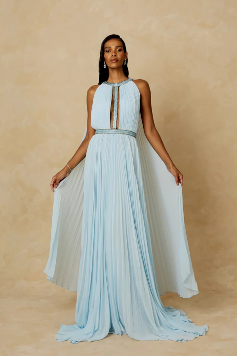 Vestido Hera Bordado Longo azul piscina, plissado, com gola halter bordada, fenda central e caimento fluido, exibido por modelo em fundo neutro.