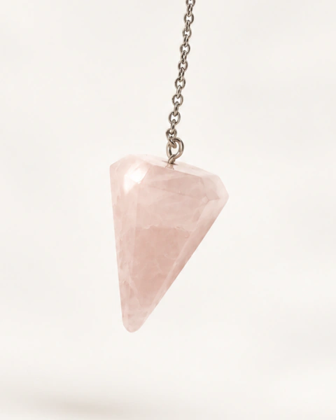 Péndulo de cuarzo rosa natural facetado colgando de una cadena metálica