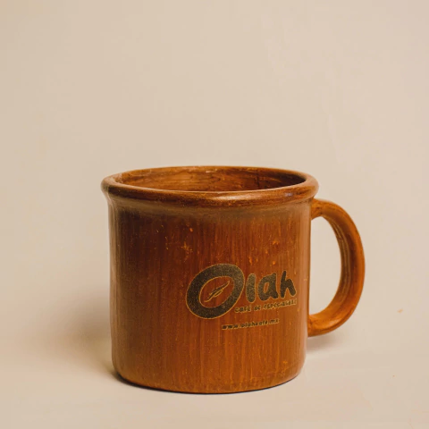 Taza artesanal de barro color café con el logo de Olah Café impreso, con asa y acabado rústico