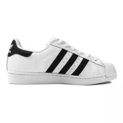 Tênis Adidas Superstar na cor branca com detalhes em preto, mostrando seu design clássico e icônico.