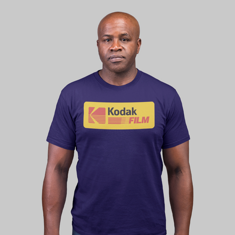 Homem vestindo camiseta unissex plus size azul com estampa amarela "Kodak Film", estilo retrô e nostálgico.