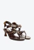 Sandália feminina em couro chocolate, salto baixo escultural, detalhes metálicos dourados. Perfeita para looks sofisticados. Garanta já a sua!