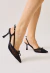 Slingback em tela preta com salto médio taça, laço frontal e bico fino. Toque moderno e romântico, perfeito para looks elegantes. Garanta o seu!
