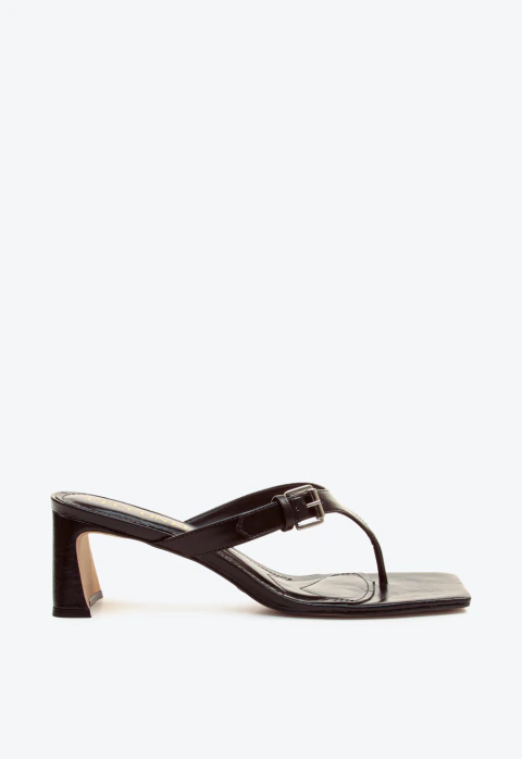 Tamanco em couro preto, salto bloco baixo 5,5cm, design minimalista, bico quadrado e fivela elegante. Conforto chique para looks urbanos. Garanta já o seu!