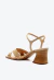Sandália couro nude com tiras cruzadas, tachas douradas e salto bloco médio. Elegância e conforto para qualquer ocasião. Garanta a sua Cecconello!