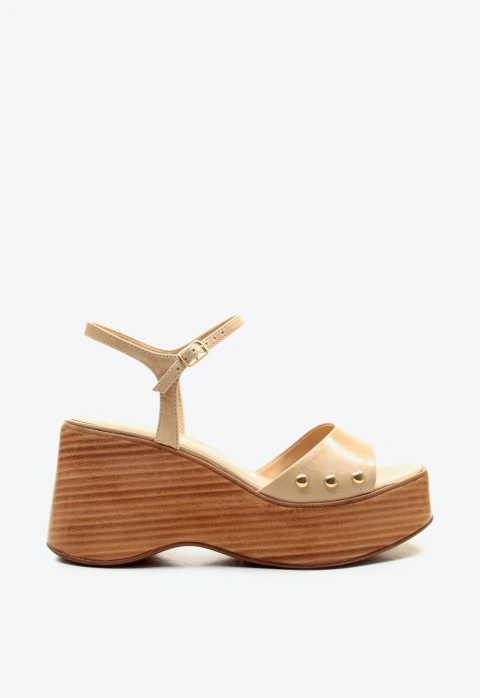 Sandália plataforma Cecconello em couro nude, salto anabela 9cm, tachas douradas e fechamento delicado. Perfeita para looks sofisticados. Compre já!