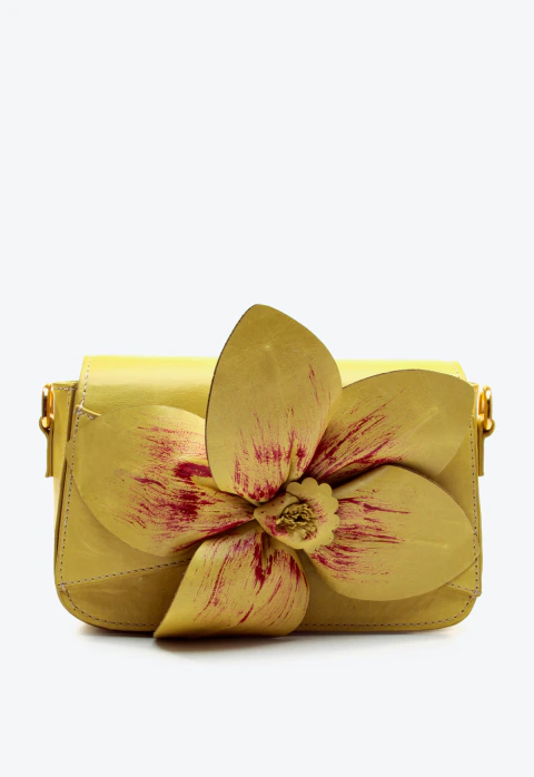 Bolsa em couro verde limone, flor 3D magenta, alça removível e metais dourados. Sofisticação e cor para seu look. Garanta a sua Cecconello!