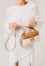 Bolsa baú box Cecconello em couro marrom e linho cru, com alça removível, espelho integrado e design utilitário-chique. Garanta já a sua elegância!