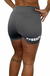 Vista trasera de mujer usando short deportivo gris para CrossFit con logo blanco