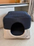 Toca para cachorro em tecido marinho e base bege, modelo Clean da marca Bonito pra Cachorro, colocada sobre tapete claro em ambiente interno