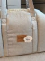 Bolsa de transporte para cachorro em tecido linen bege com alças e etiqueta da marca Bonito pra Cachorro