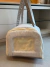Bolsa de transporte para cachorro em tecido linen bege com tela de ventilação frontal e alças para carregar