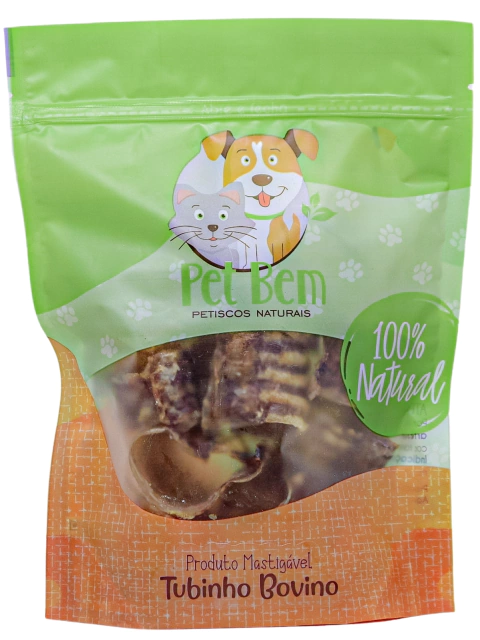 Produto Tubinho Bovino de 100g feito com traqueia desidratada em sua embalagem transparente com detalhes em laranja e verde.