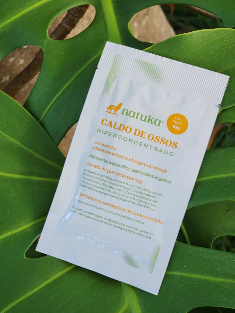 Pacote de Natuka Caldo de Ossos Bovino hiperconcentrado de 10g sobre folhas verdes