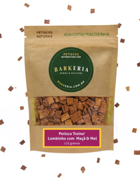 Embalagem do petisco Treino de Lombinho, Maçã e Mel da Barkeria, embalagem transparente com detalhes em cores marrom e verde escuro, petisco natural e artesanal para cães.