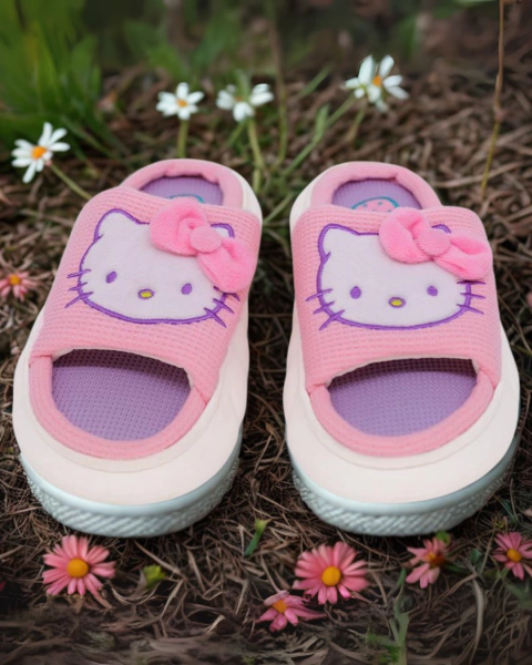 Pantufa rosa com estampa da Hello Kitty e laço rosa, com solado antiderrapante, sobre chão com flores