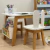 Mesa infantil Dora com cadeiras de madeira e detalhes brancos, ideal para crianças, em ambiente de quarto infantil.