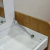 Penteadeira Regulável Gus em madeira clara e branco, com tampa basculante, espelho interno e compartimentos organizadores.


