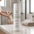 Frasco de Shampoo Adulto Ybá Pet com Barbatimão para cães e gatos, 250ml, sobre bancada de banheiro, com cachorro ao fundo sendo banhado.