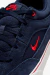 Zapatilla Nike SB Malor color obsidian con detalles en rojo, vista de cerca mostrando el material de gamuza y el logo Swoosh bordado.