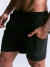 Homem vestindo short masculino preto com bolso lateral e cordão ajustável na cintura