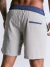 Short masculino cinza com cós azul e bolso traseiro, visto de costas