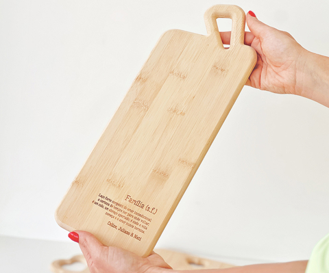 Tábua de bambu baguete com cabo personalizada sendo segurada por uma pessoa, ideal para frios e pães.
