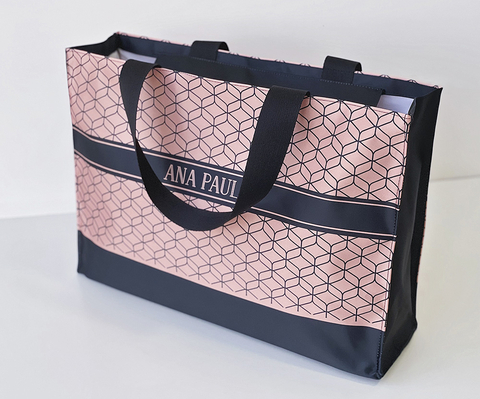 Bolsa personalizada grande com estampa geométrica rosa e preta, alças pretas e nome personalizado na faixa central, ideal para praia ou presente.