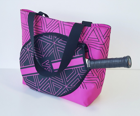 Bolsa personalizada para beach tennis neon na cor rosa com detalhes geométricos pretos, alças pretas e compartimento especial para raquete.