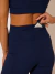 Short feminino azul marinho de alta compressão com três bolsos, modelo Athletic Power, usado por mulher em look esportivo.
