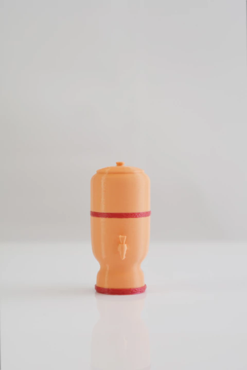 Chaveiro miniatura de filtro de barro brasileiro em impressão 3D, cor laranja com detalhes vermelhos, medindo 5 cm