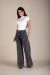 Mulher vestindo calça wide basic jeans preta com lavagem escura e blusa branca de manga curta