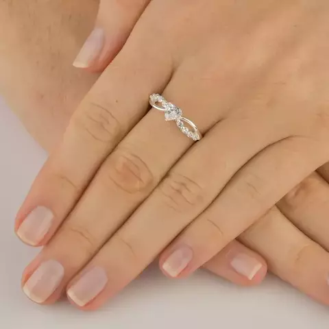 ANEL COM UM ARO CRAVEJADO E OUTRO LISO QUE SE CRUZAM E ZIRCÔNIA DE CORAÇÃO NO MEIO