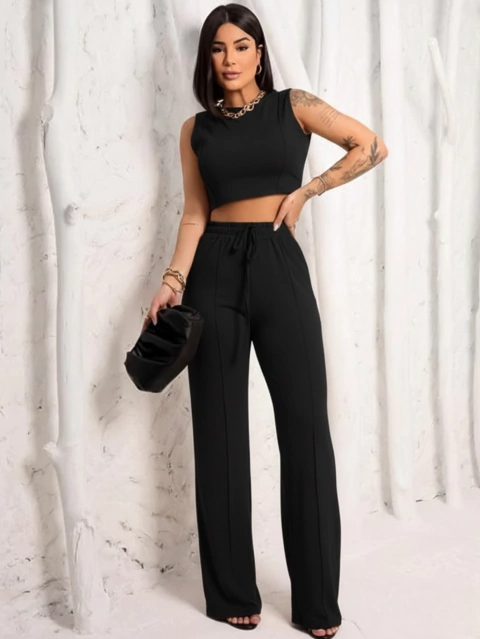 Mulher usando conjunto moletinho preto com cropped sem manga e calça de cintura alta com cordão
